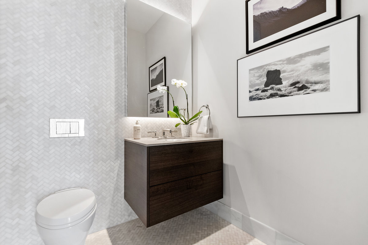 Powder room with herringbone marble floor and wall